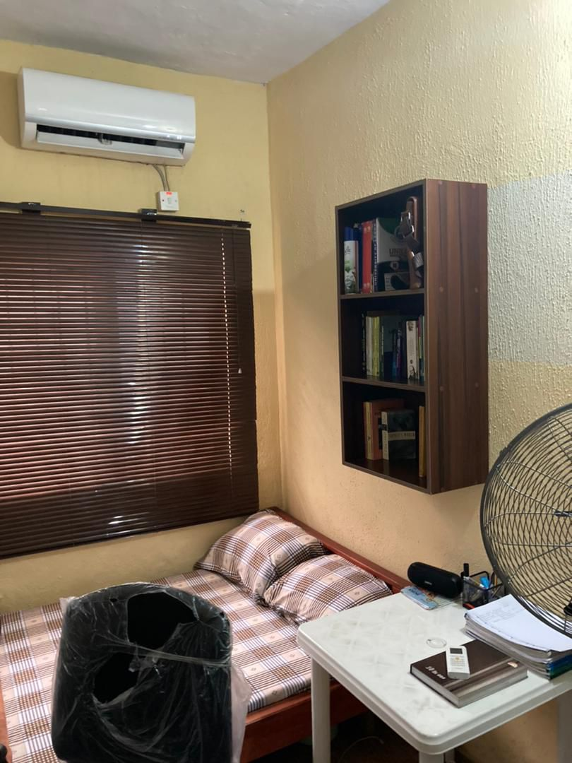 Bed space room at Rilwan AJALA Homes Yaba Lagos with two separate beds and ceiling fan