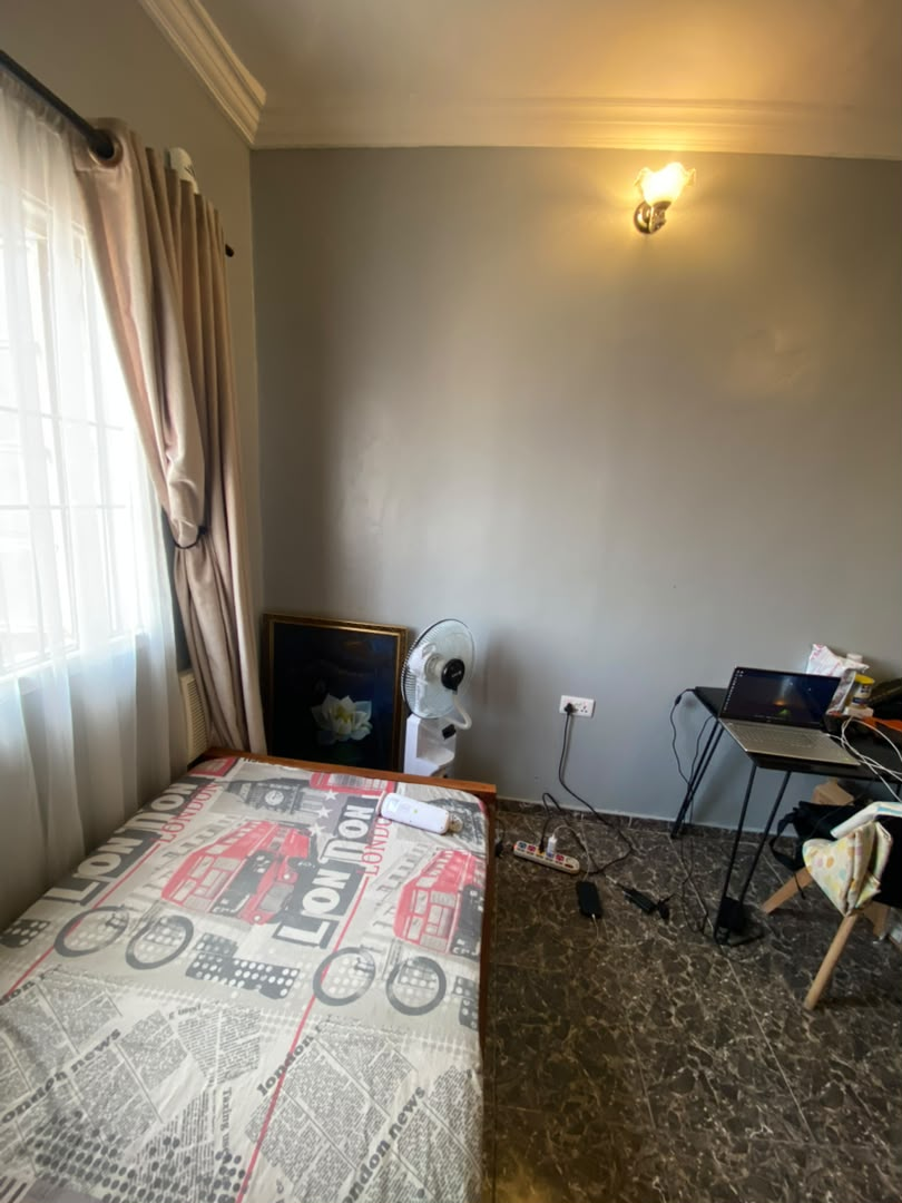 Single room at Rilwan AJALA Homes with grey walls and curtains